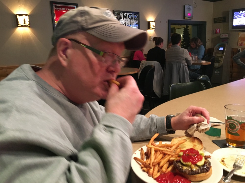 My dad enjoying a bacon cheeseburger and fries; a favorite meal for both of us. (Photo by: Tyler Jensen)